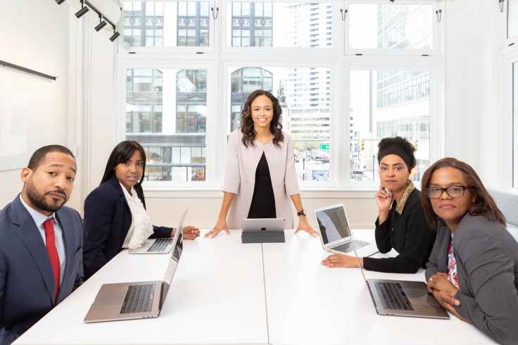 woman standing on the center table with four people on the side