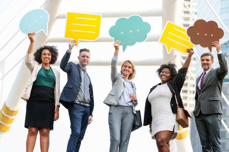 five standing people holding message clouds